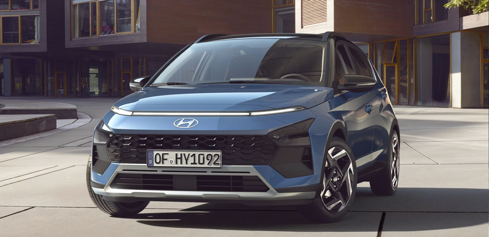 The new Hyundai BAYON is seen the front, with urban housing in the background.