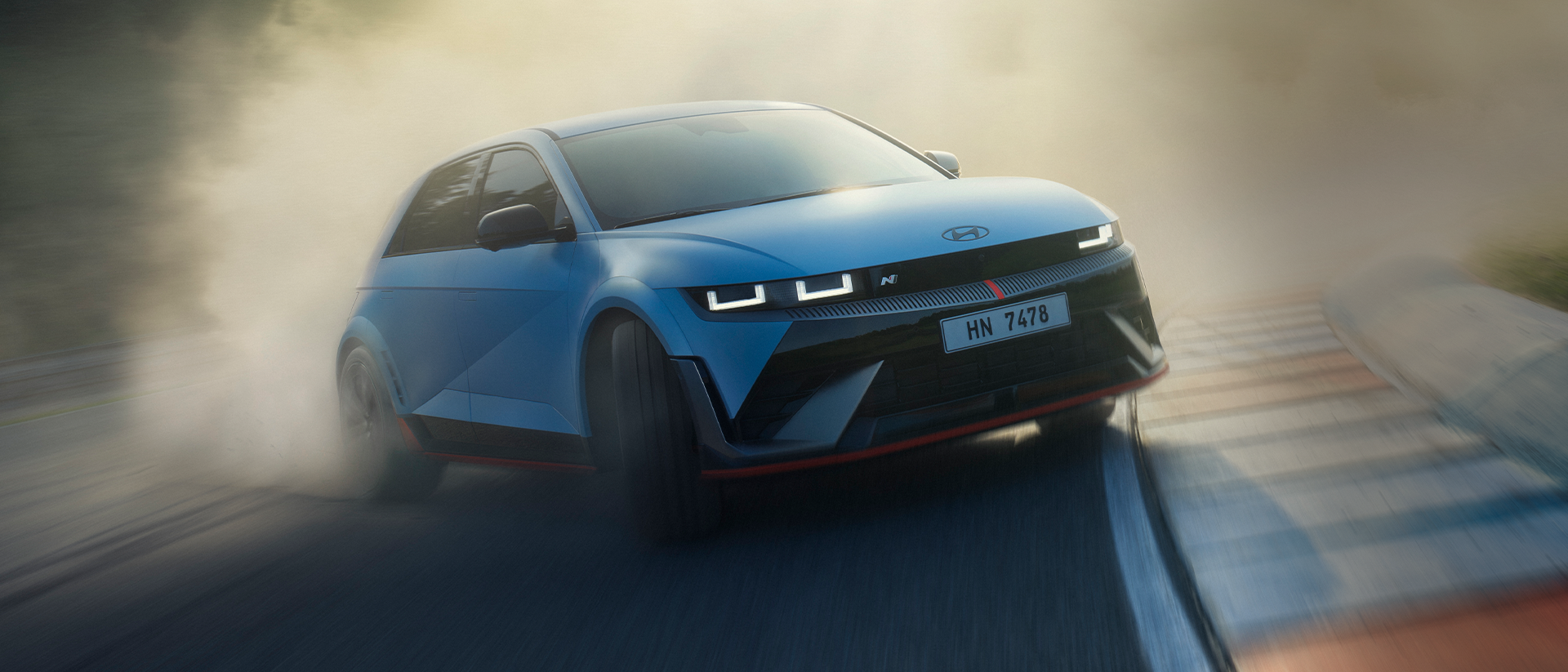 The all-electric Hyundai IONIQ 5 N drifting through a curve on a racetrack with smoking tyres.