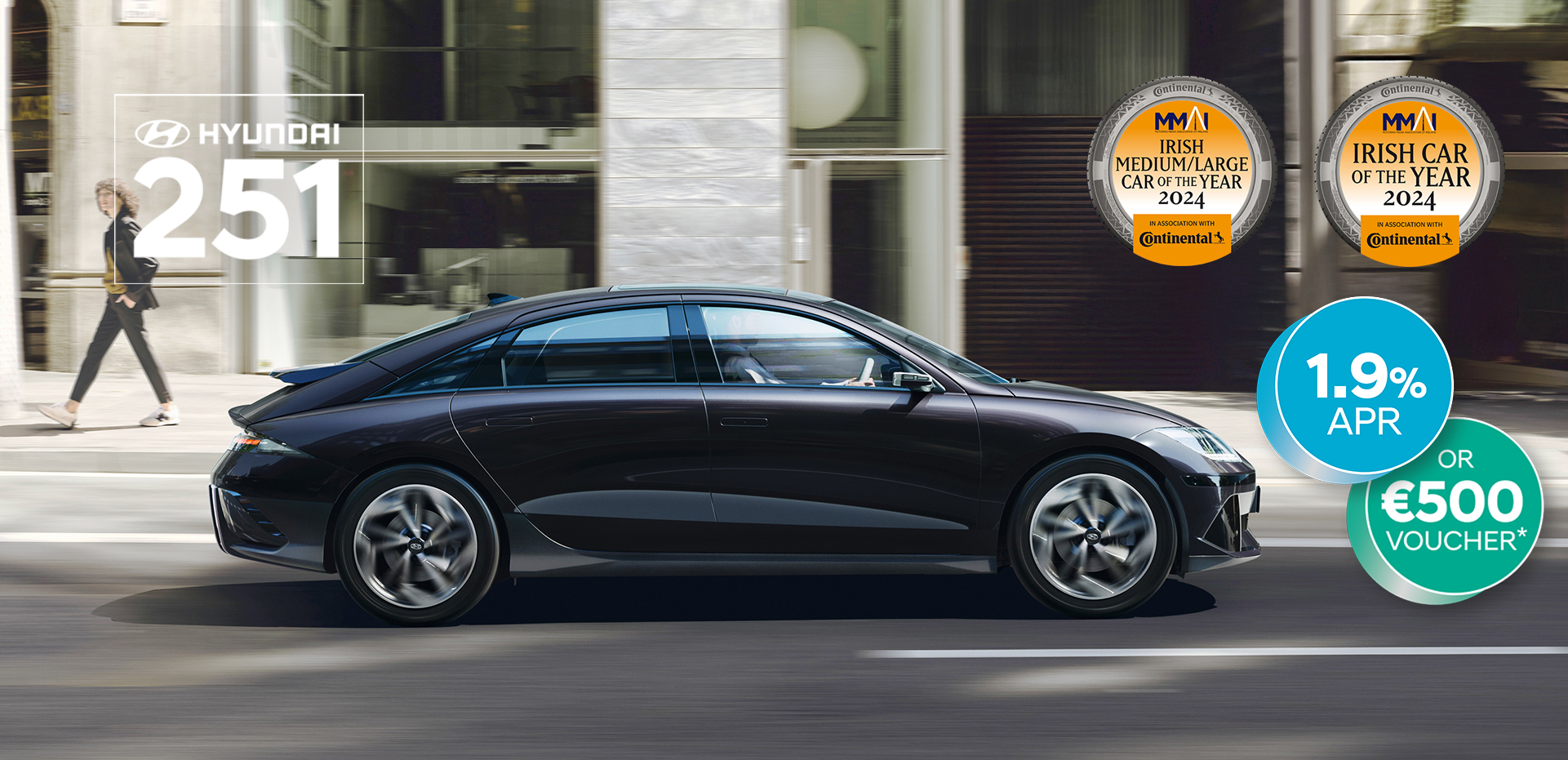 The all-electric Hyundai IONIQ 6 charging in a city with a man leaning on it with an ice cream.