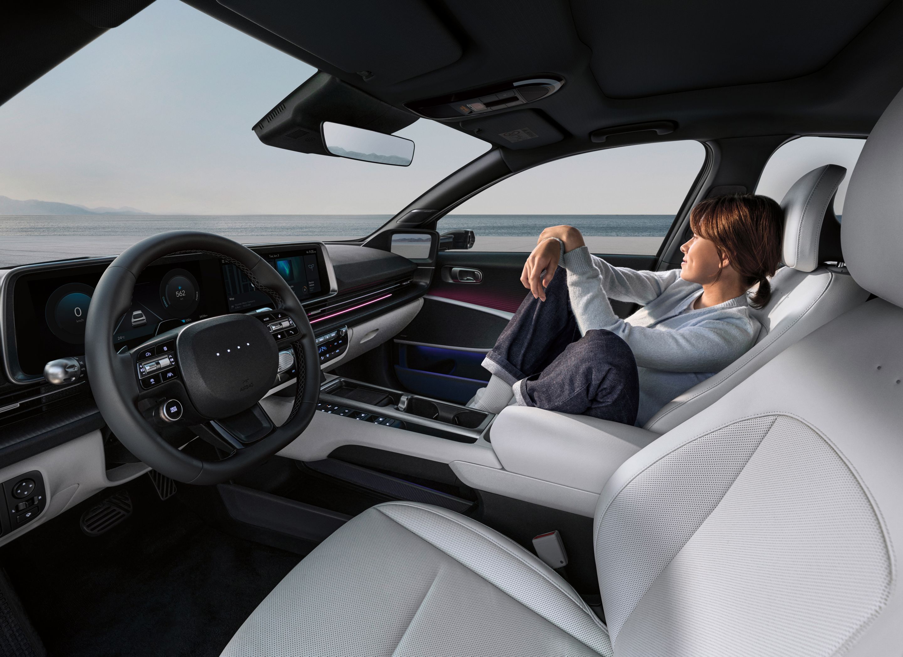 A woman relaxing in the front passenger seat of the Hyundai IONIQ 6.