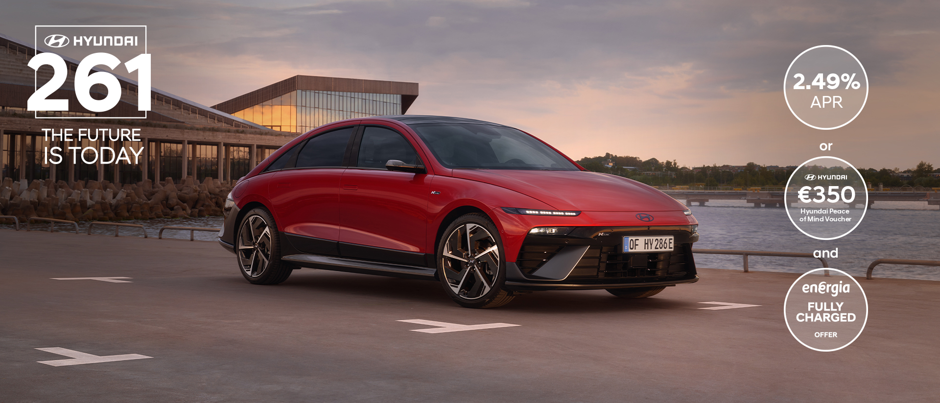 Hyundai IONIQ 6 electric sedan shown from the side parked on a city street with high rise buildings.