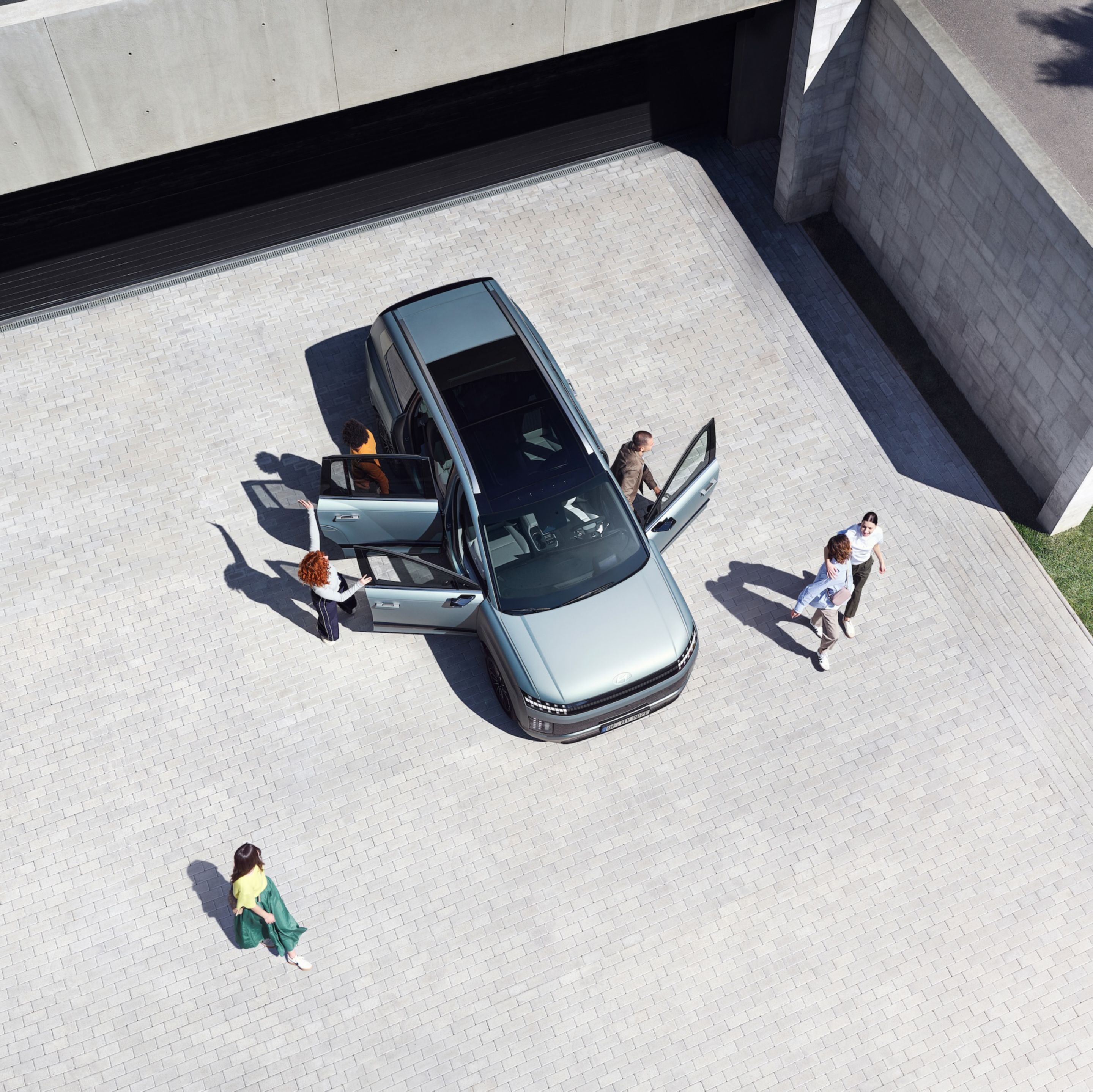 Top view of the IONIQ 9 with 6 people getting out of the car.