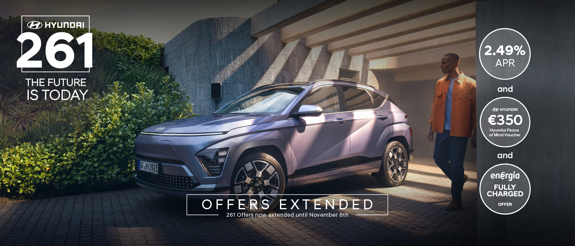 The Hyundai KONA Electric bathed in sunlight with a man walking away from a garage.