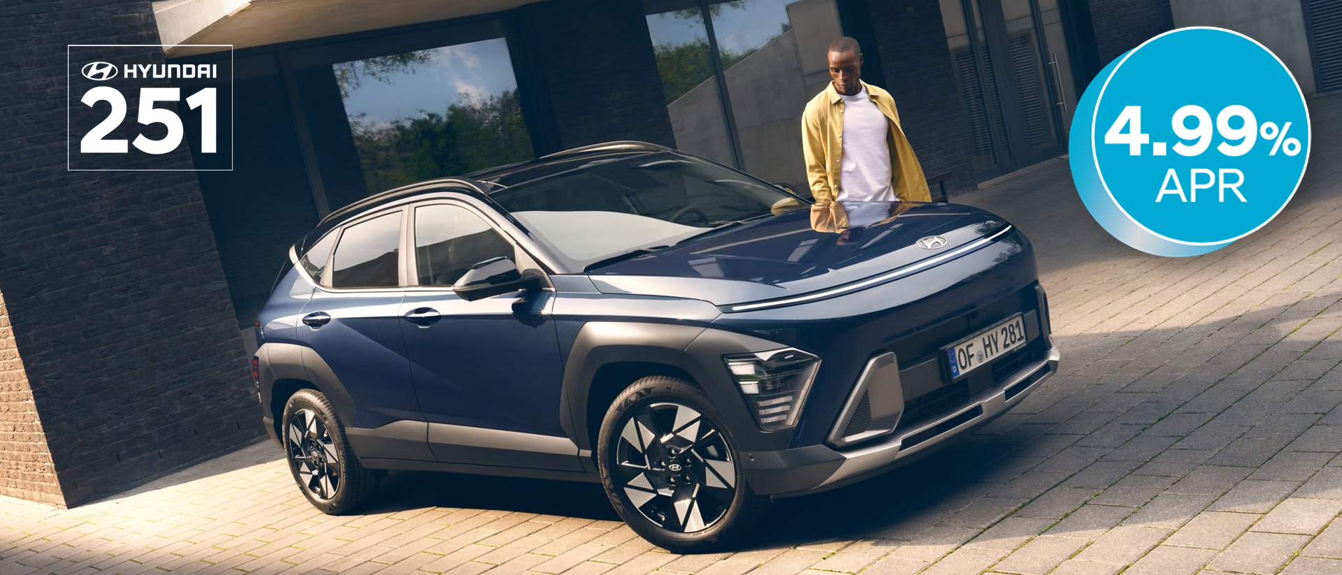 The all-new Hyundai KONA in blue parked next to a men with yellow shirt.