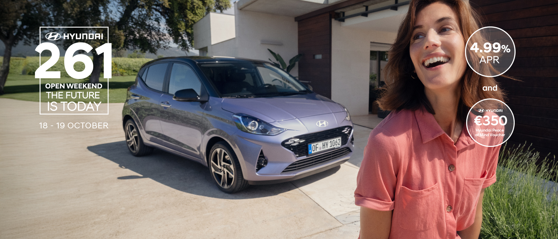 A woman walking and smiling in front of the new Hyundai i10.