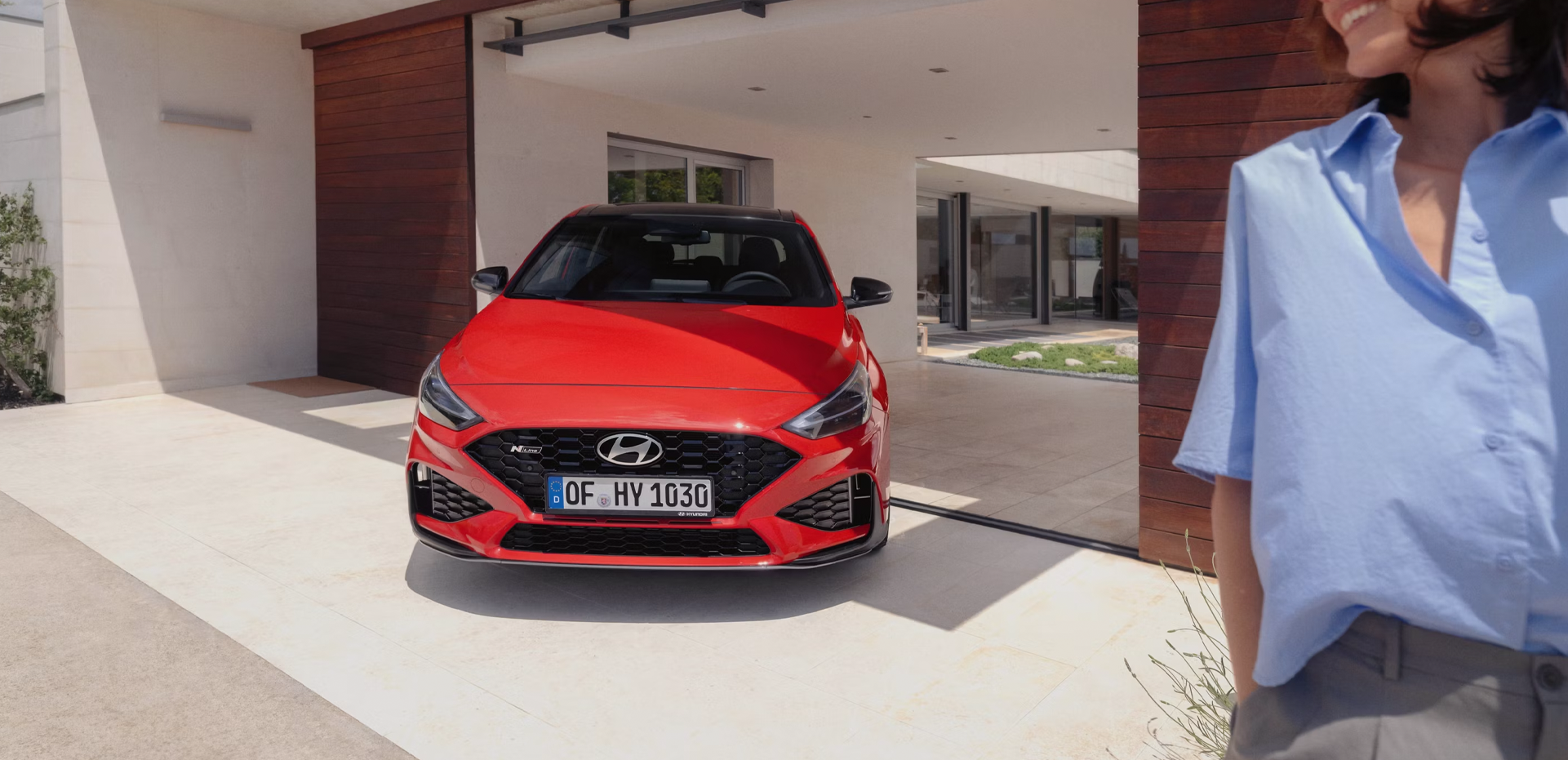 The new Hyundai i30 N Line in red parked in front of the house.