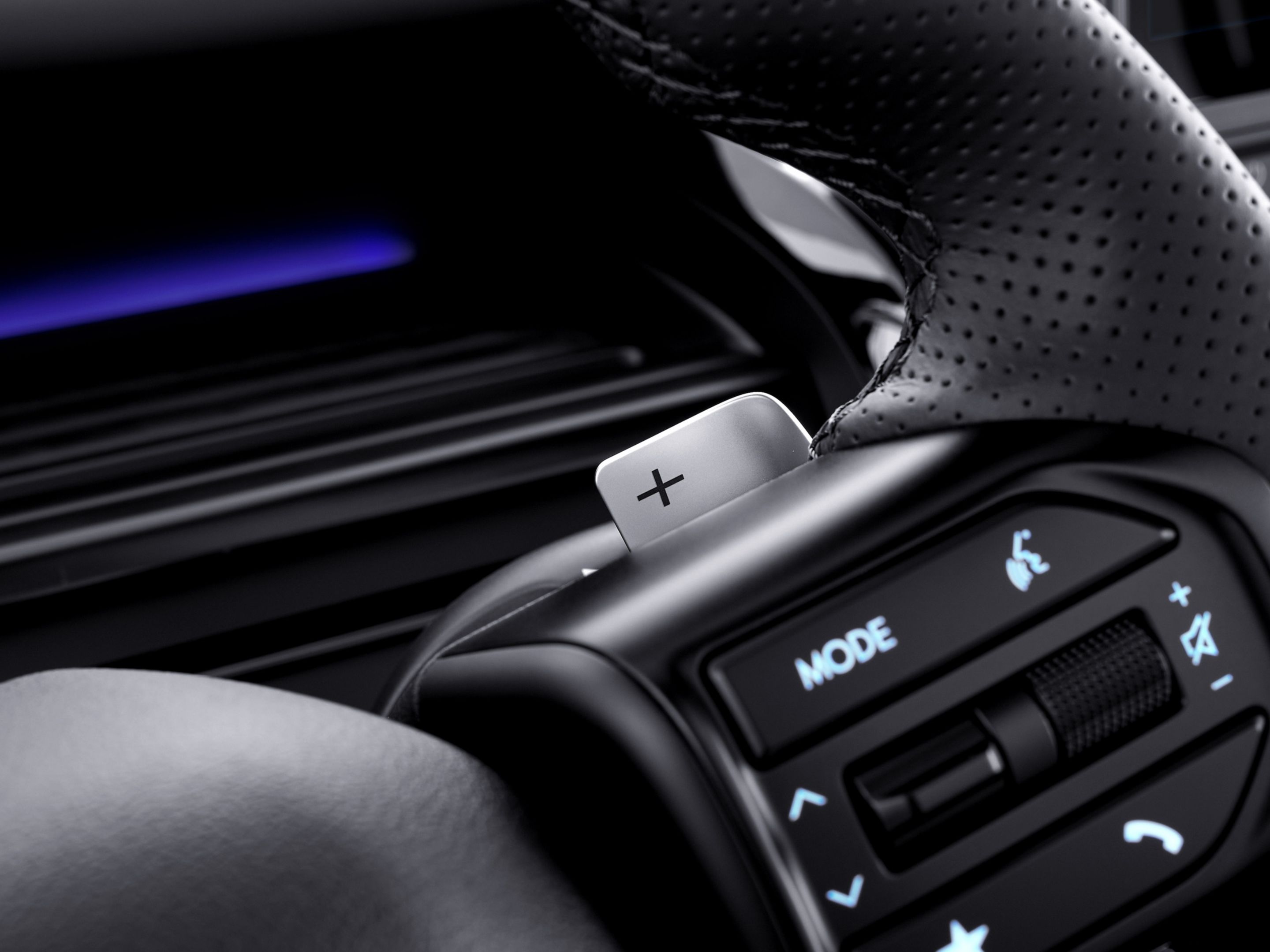 Close-up of Hyundai STARIA Electric steering wheel with integrated controls and paddle shifter.