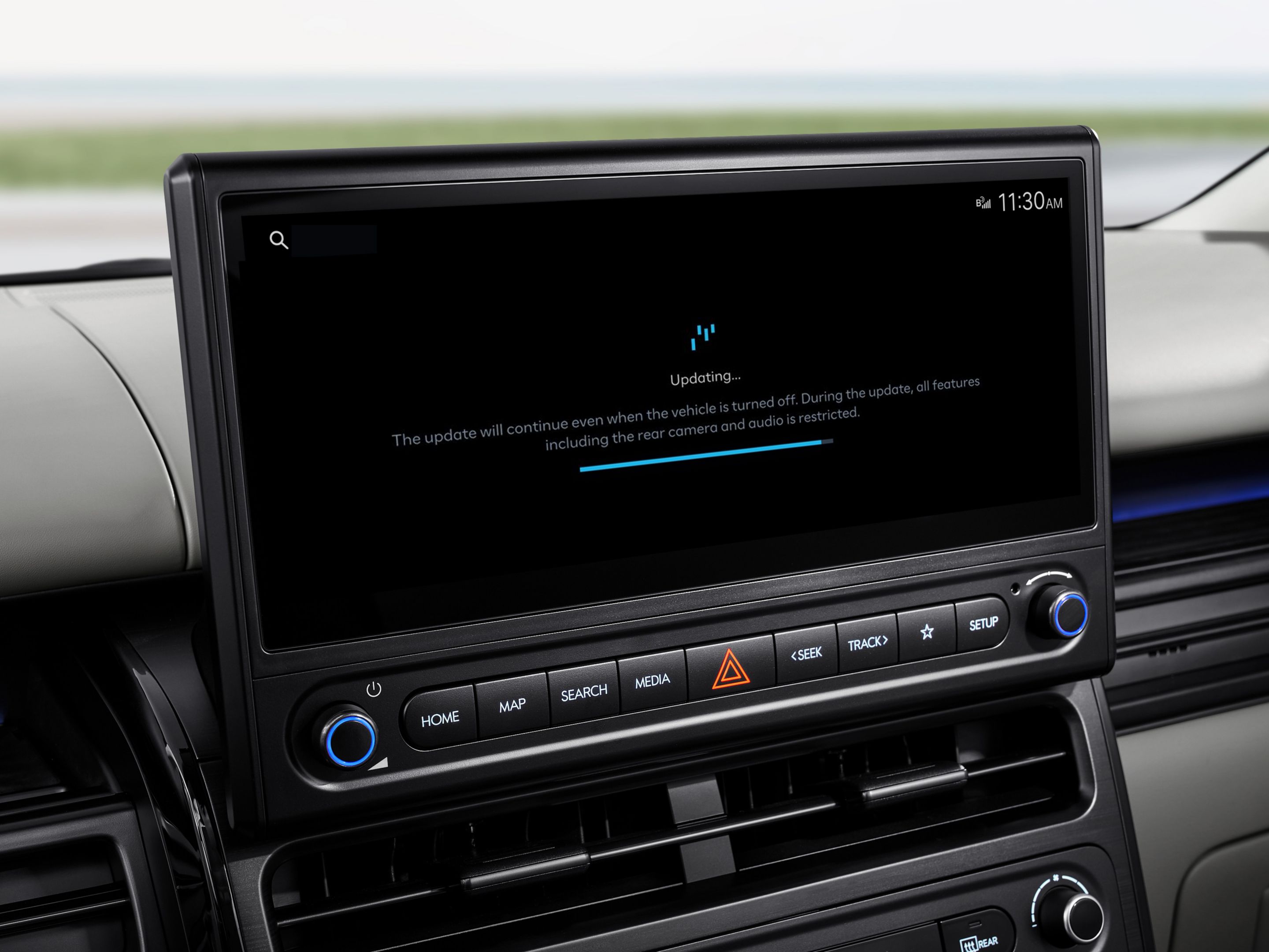 Close-up of the Hyundai STARIA Electric front end with open charging port and plugged-in charging cable.