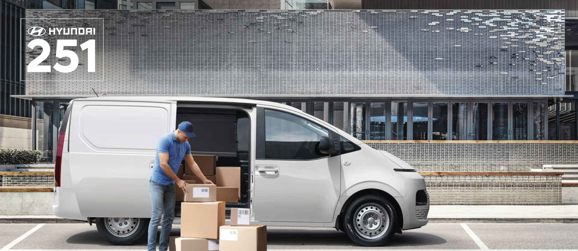 The all-new STARIA Van parked at a curb, delivery guy unpacking from the side door.