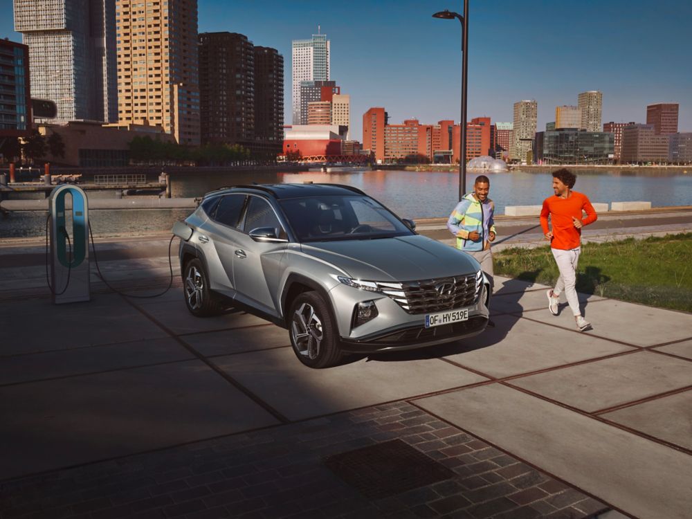 Two Joggers look at the all-new Hyundai TUCSON Plug-in Hybrid N Line while loading.